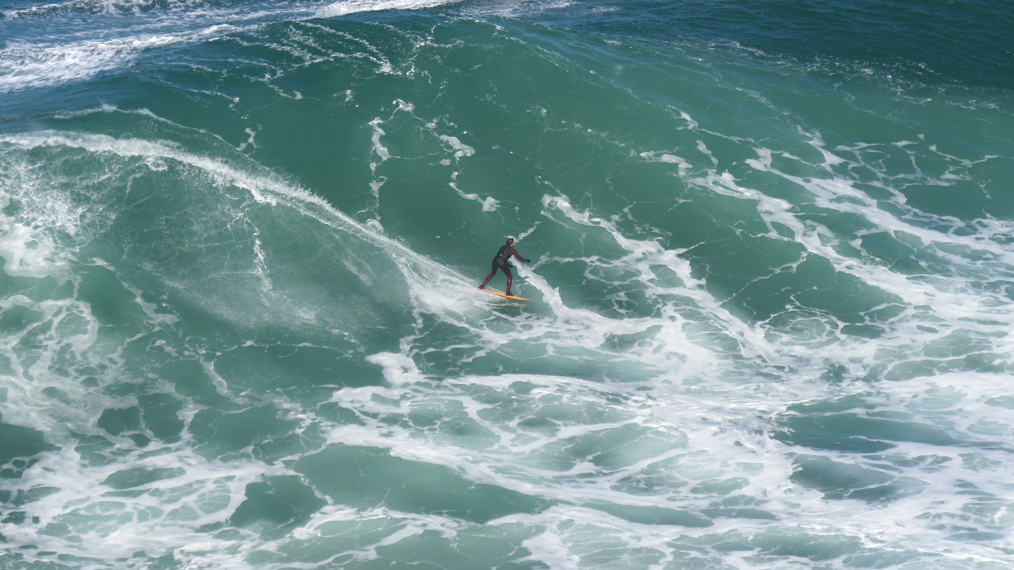 Diese Welle ist schon um einiges größer als der Surfer